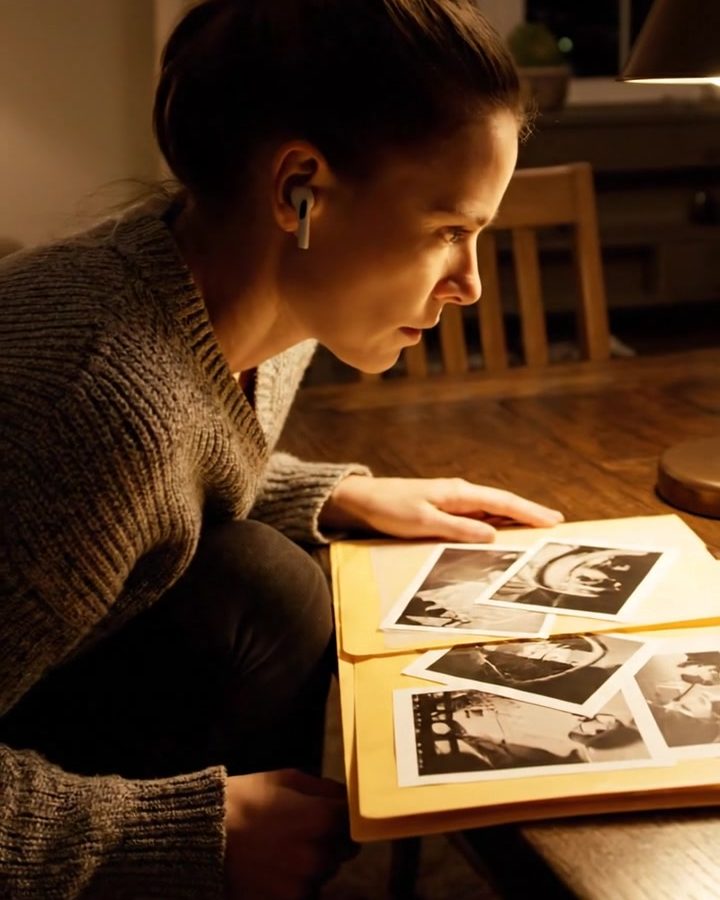 Mulher analisa um dossiê de fotografias